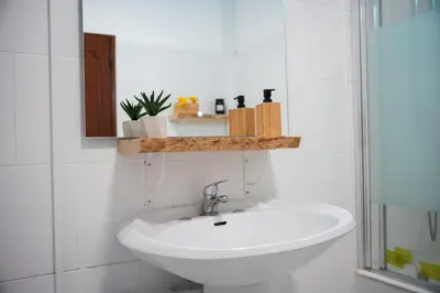 a white bathroom with a sink and a mirror at Old Town Apartment Panoramic NearThe Beach in Albufeira