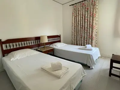 a bedroom with two beds and a window at A Villa in Quarteira