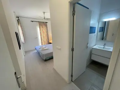 a bathroom with a bed and a sink and a mirror at A Villa in Quarteira