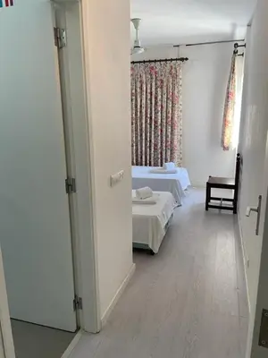 a room with two beds and a door to a bedroom at A Villa in Quarteira