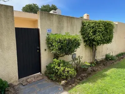 a house with a black door and some bushes at A Villa in Quarteira