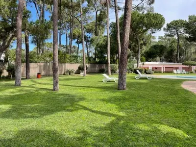 a park with two picnic tables and palm trees at A Villa in Quarteira