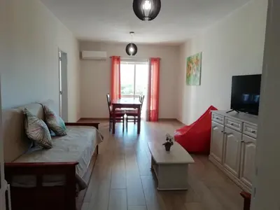 a living room with a couch and a table at Apartamento laranja in Quarteira