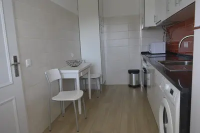 a small kitchen with a table and chairs in it at Apartamento laranja in Quarteira