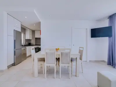 a kitchen and dining room with a white table and chairs at AL - Atlântida Penthouse in Quarteira