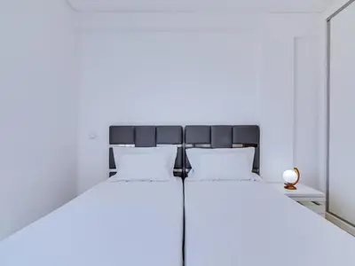 two beds in a room with white walls at AL - Atlântida Penthouse in Quarteira