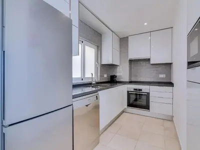 a white kitchen with white cabinets and appliances at AL - Atlântida Penthouse in Quarteira