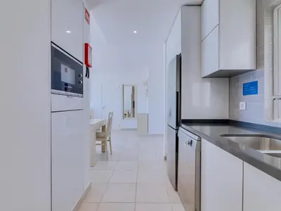a white kitchen with a sink and a refrigerator at AL - Atlântida Penthouse in Quarteira