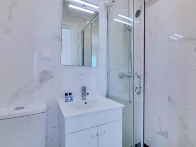 a white bathroom with a sink and a shower at AL - Atlântida Penthouse in Quarteira