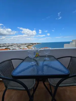 a table with two wine glasses on a balcony at SEAVIEW ALBUFEIRA in Albufeira