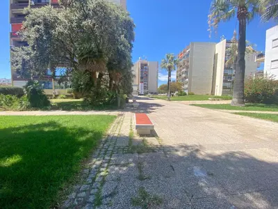 a street in a park with palm trees and buildings at Marina Walk Apartment in Vilamoura