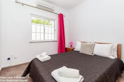 a bedroom with a bed with a red curtain at Akisol Albufeira Sun in Albufeira