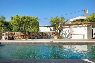a swimming pool in front of a house at Pine Lodge in Vilamoura
