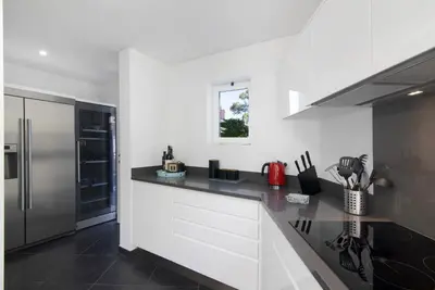 a kitchen with white cabinets and a black counter top at Pine Lodge in Vilamoura