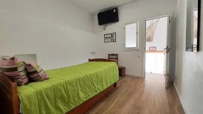 a bedroom with a green bed and a television at T3 Centro de Albufeira com piscina in Albufeira