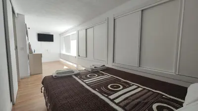 a bedroom with a bed and large windows at T3 Centro de Albufeira com piscina in Albufeira