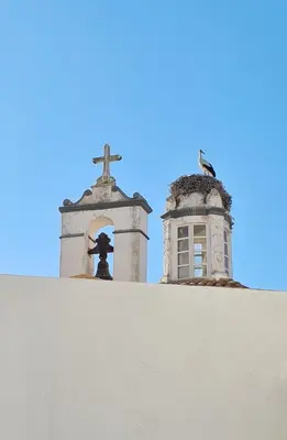 a cross on top of a wall next to a church at The Singular - Downtown Studio in Faro