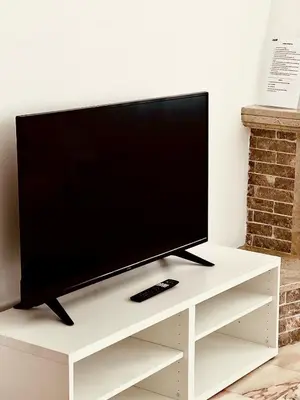 a flat screen tv sitting on a white tv stand at Porta 12 in Faro