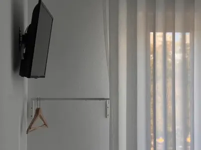 a television on a wall next to a window at Porta 12 in Faro