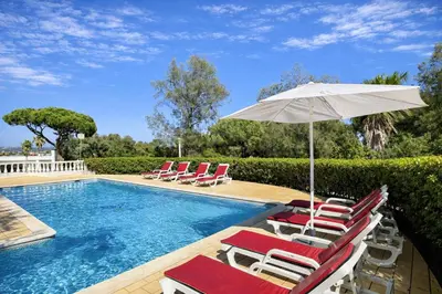a swimming pool with lounge chairs and an umbrella at Poço by Check-in Portugal in Albufeira
