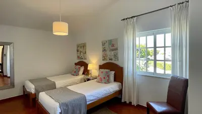 two beds in a room with a window at Poço by Check-in Portugal in Albufeira