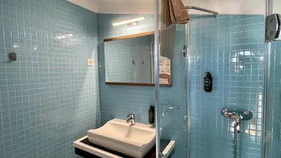 a blue tiled bathroom with a sink and a shower at Poço by Check-in Portugal in Albufeira