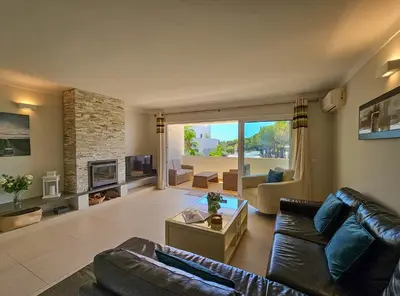 a living room with a leather couch and a fireplace at FLH Quinta das Salinas Triplex with Terrace & Pool in Vale do Lobo