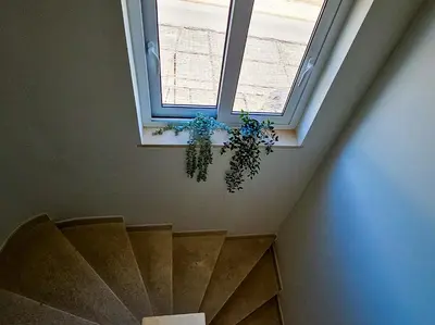 a plant hanging from a window in a stair case at FLH Quinta das Salinas Triplex with Terrace & Pool in Vale do Lobo