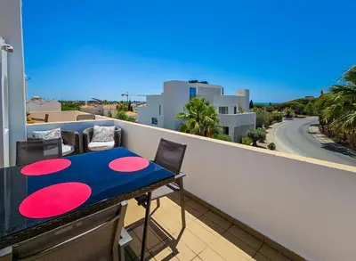 a table on a balcony with a view of a street at FLH Quinta das Salinas Triplex with Terrace & Pool in Vale do Lobo