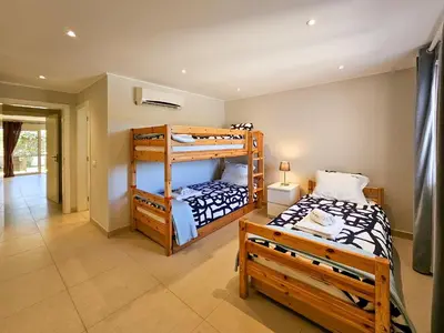 two bunk beds in a room with a bedroom at FLH Quinta das Salinas Triplex with Terrace & Pool in Vale do Lobo