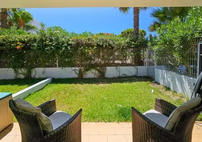 a patio with two chairs and a yard at FLH Quinta das Salinas Triplex with Terrace & Pool in Vale do Lobo