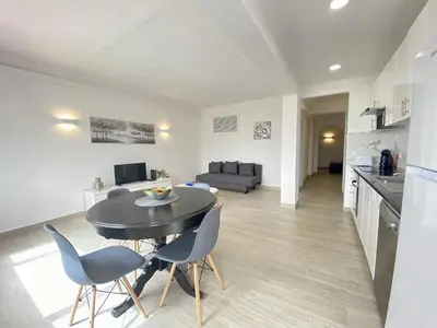 a kitchen and living room with a table and chairs at Albufeira Central 6 by Homing in Albufeira