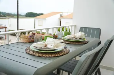 a blue table with plates and napkins on a balcony at Martina Apartment - SeaView in Albufeira