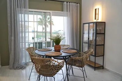a dining room with a table and chairs and a window at Martina Apartment - SeaView in Albufeira