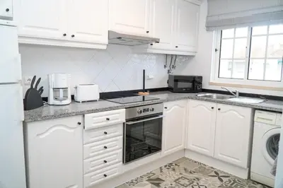 a white kitchen with white cabinets and a sink at Martina Apartment - SeaView in Albufeira