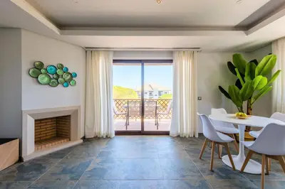 a living room with a fireplace and a table and chairs at Falesia Beach C in Albufeira