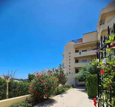 a building with flowers on the side of a sidewalk at Cosy & Airy @ Albufeira in Albufeira