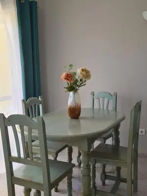 a vase of flowers sitting on a table with chairs at Cosy & Airy @ Albufeira in Albufeira