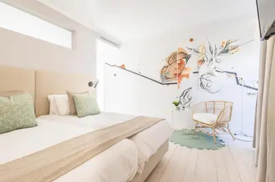 a bedroom with a bed and a chair at LODO Suites Ria - Private Room by HD in Faro