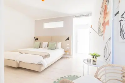 a white bedroom with a bed and a table at LODO Suites Ria - Private Room by HD in Faro