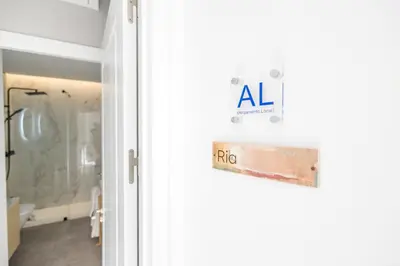 a door with a sign on it next to a bathroom at LODO Suites Ria - Private Room by HD in Faro