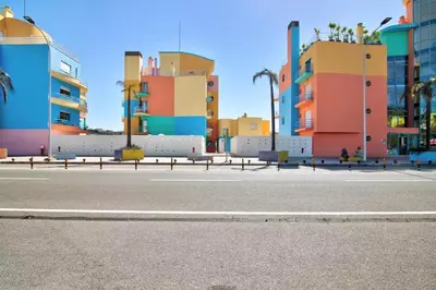 an empty street in front of some colorful buildings at Apartamento W Marina by Sunnyway in Albufeira