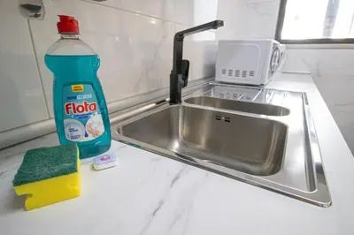 a kitchen sink with a bottle of detergent next to it at Renovated Oasis Ocean View 1BD Wi-Fi Beach 3 min in Albufeira
