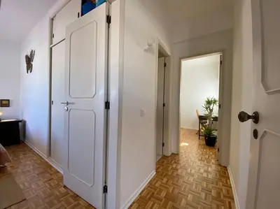a hallway with a white door and a room with a table at Superstar terrace in Faro