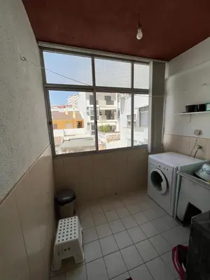 a laundry room with a washing machine and a window at CENTER HOUSE in Faro