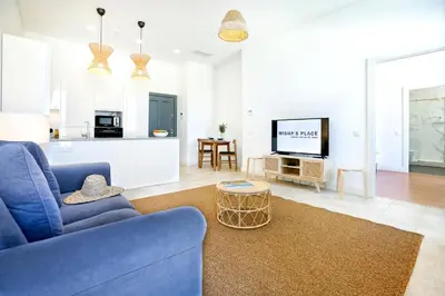 a living room with a blue couch and a tv at Lovely Faro Apartment in Faro