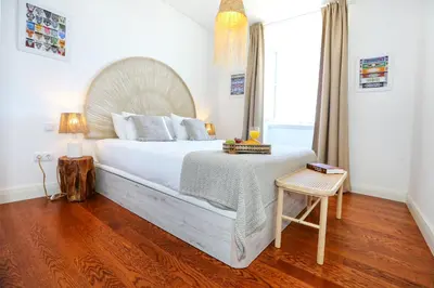 a bedroom with a large bed with a wooden headboard at Ria Formosa Vista Duplex Charm in downtown Faro in Faro