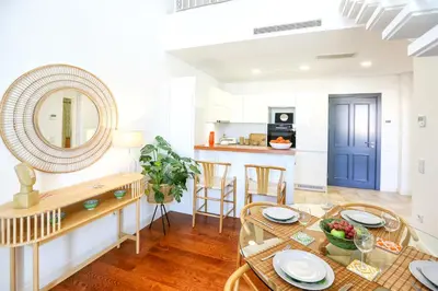 a dining room with a table and a mirror at Ria Formosa Vista Duplex Charm in downtown Faro in Faro