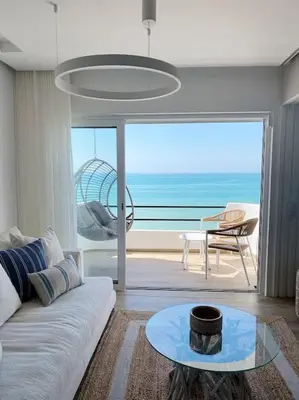 a living room with a couch and a view of the ocean at Front Sea Apartment Albufeira in Albufeira