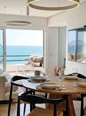 a dining room with a table and a view of the ocean at Front Sea Apartment Albufeira in Albufeira
